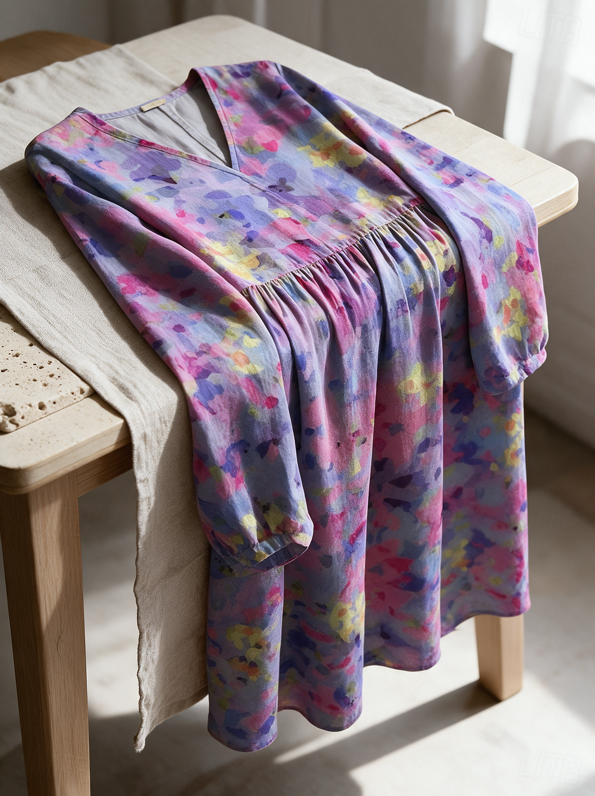 Seraphine floral midi dress folded over a wooden table