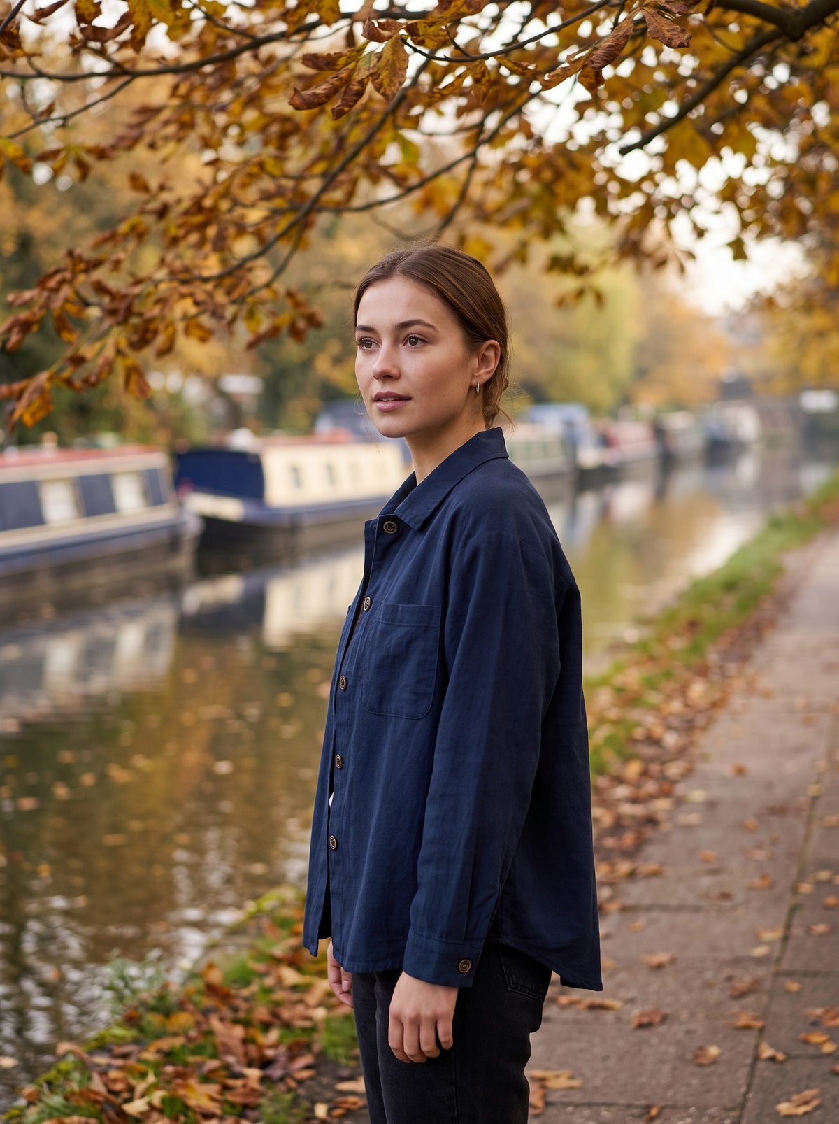 Linnea navy blue cotton shirt jacket worn by a model on a city canal towpath in autumn
