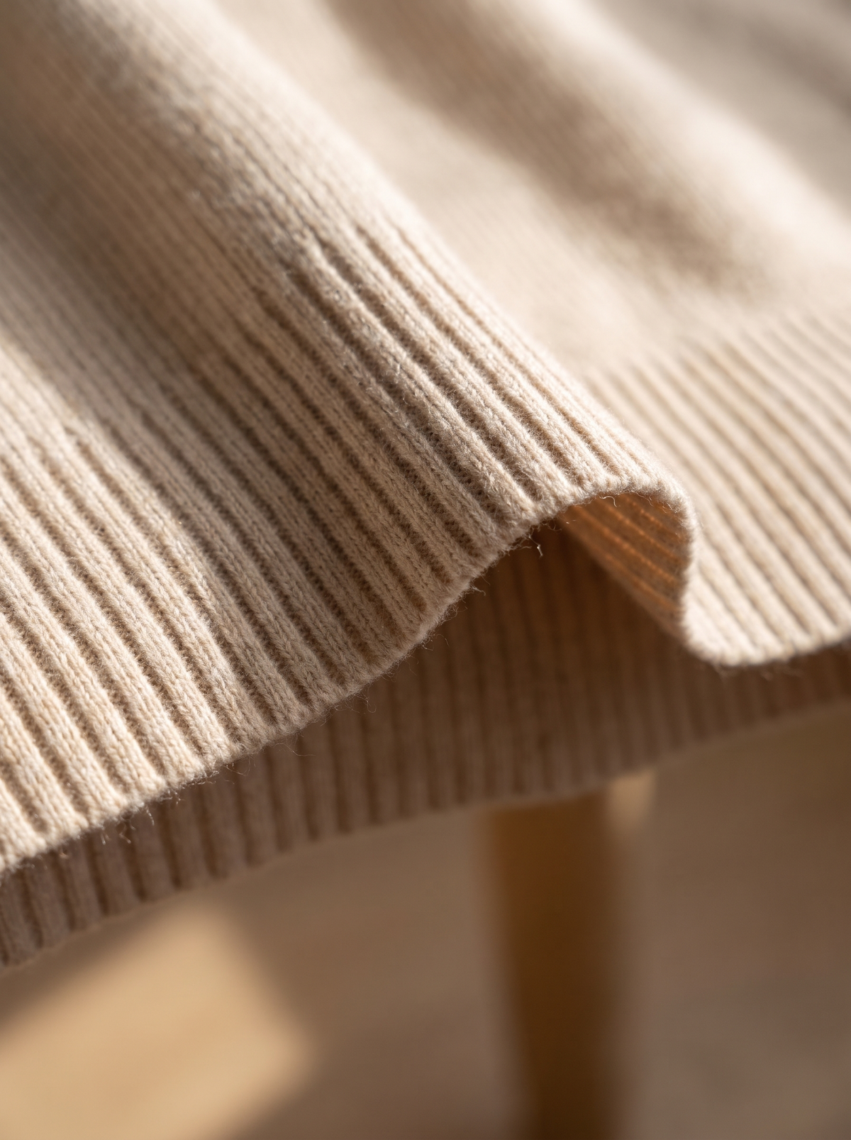 Detail of the Aurelia merino wool asymmetric sweater showing its material and finish