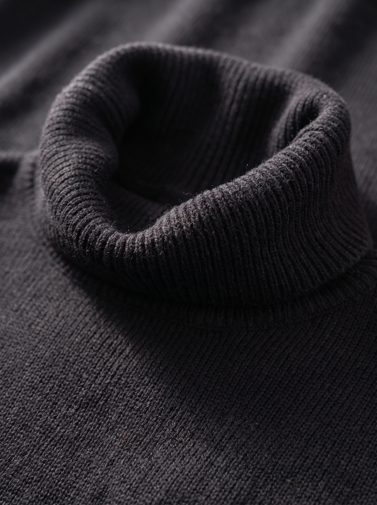 Detail of the Hesper oversized roll neck knit top showing its material and finish