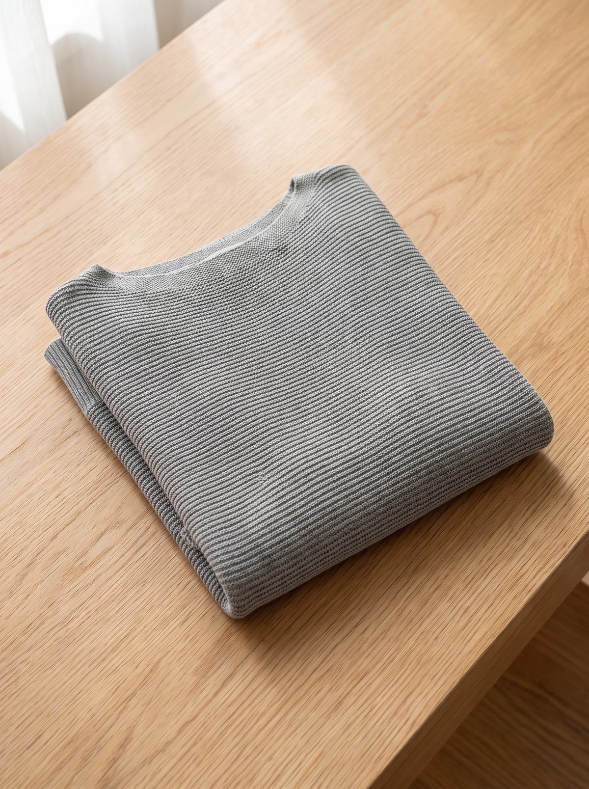 Giselle three quarter sleeve knit sweater folded neatly on a table