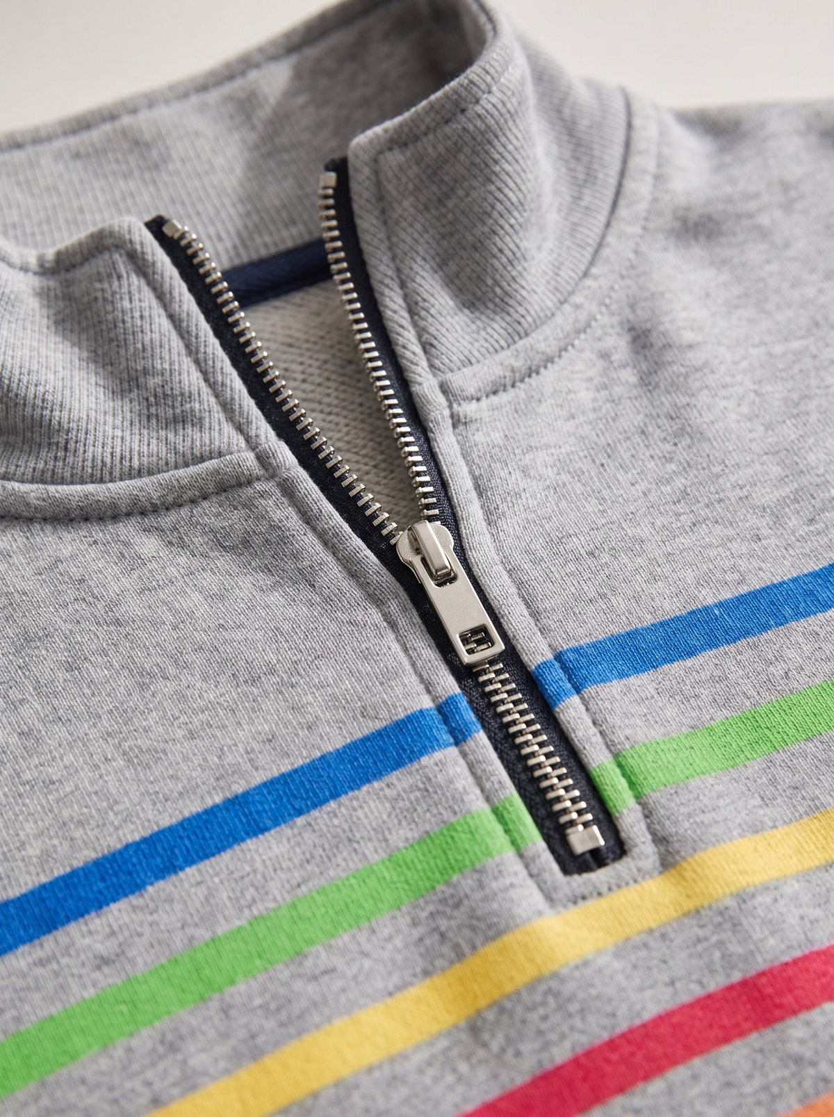 Detail of the Zephyrine striped half zip sweatshirt showing its material and finish