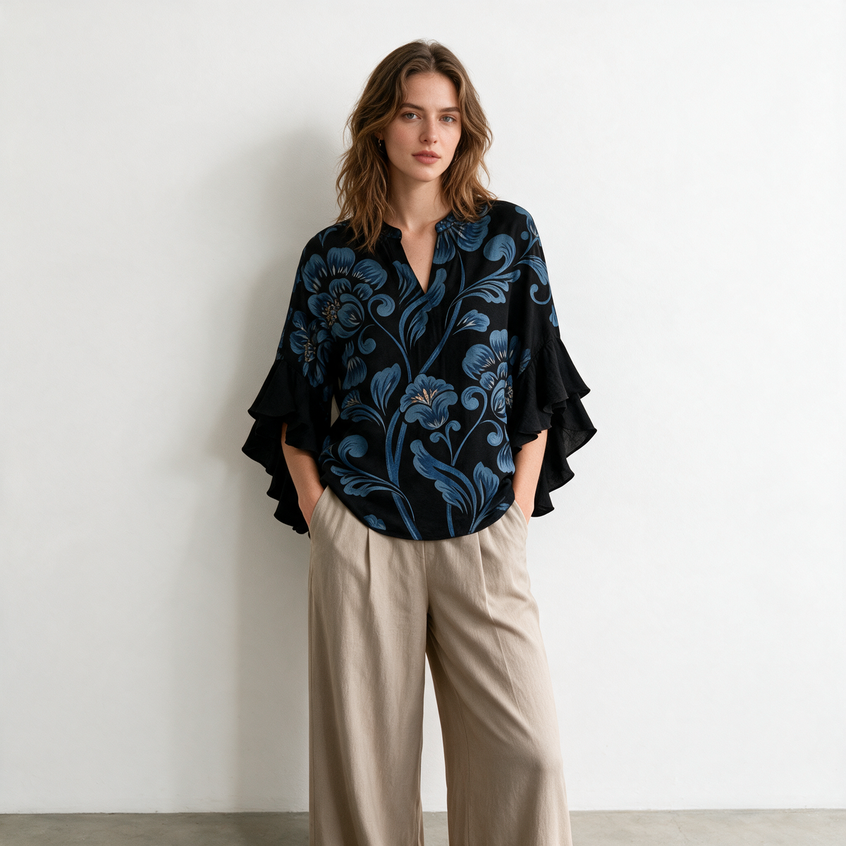 Model wearing the black Janessa blouse against a white gallery wall