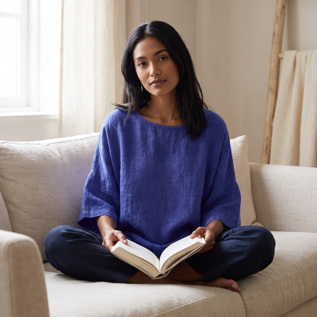 Woman on a linen sofa wearing the Blue linen blouse