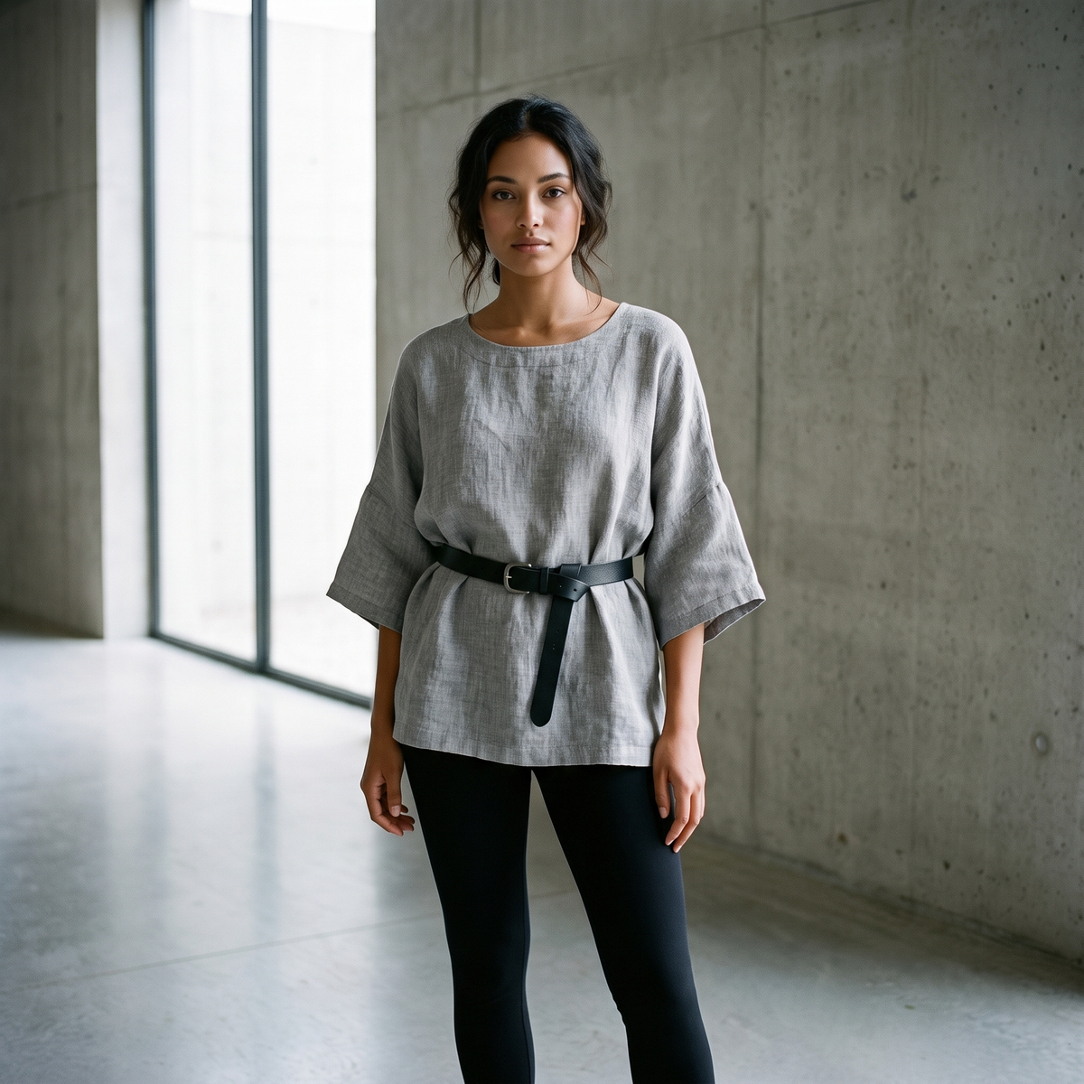 Woman in a concrete gallery wearing the Grey linen blouse