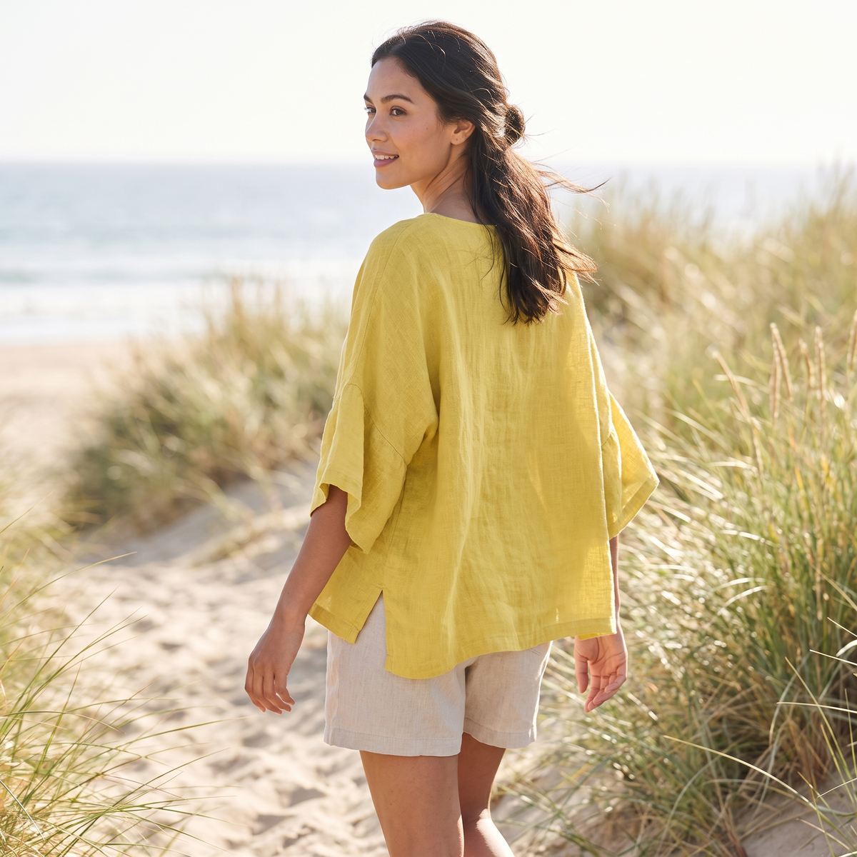 Woman on a coastal path wearing the Yellow linen blouse
