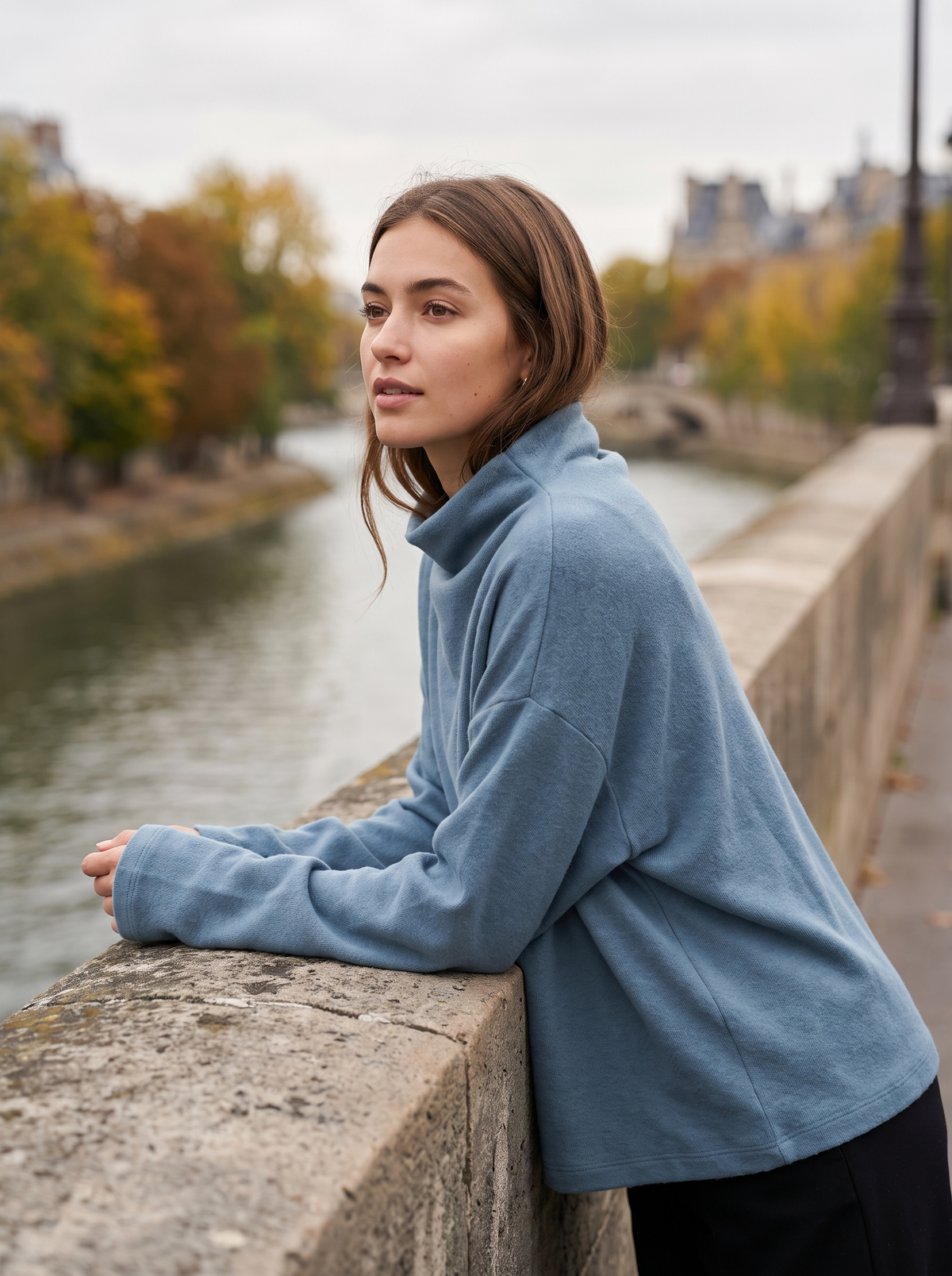 Hesper blue oversized roll neck knit top worn by a model on a city bridge in autumn