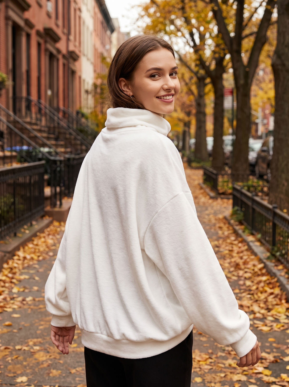 Hesper white oversized roll neck knit top worn by a model on an autumn park path in autumn