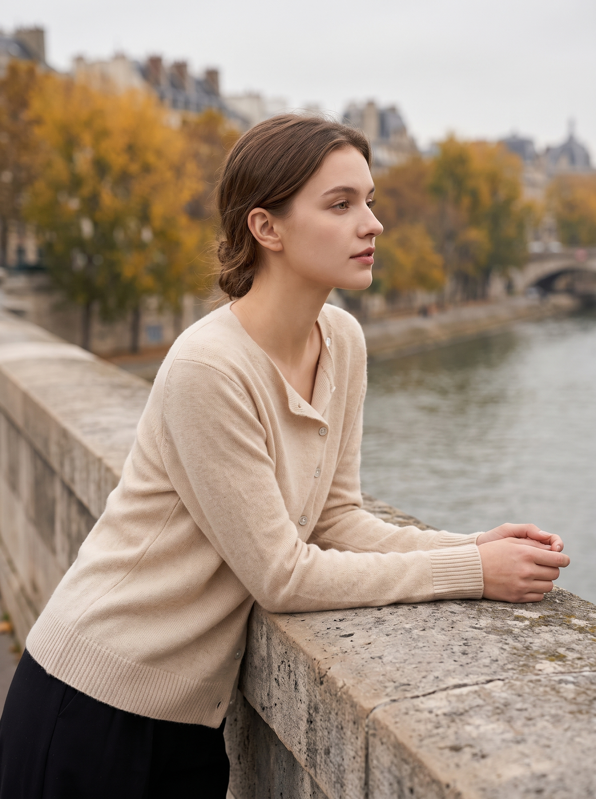 Henriette beige v neck cardigan worn by a model on a city bridge in autumn