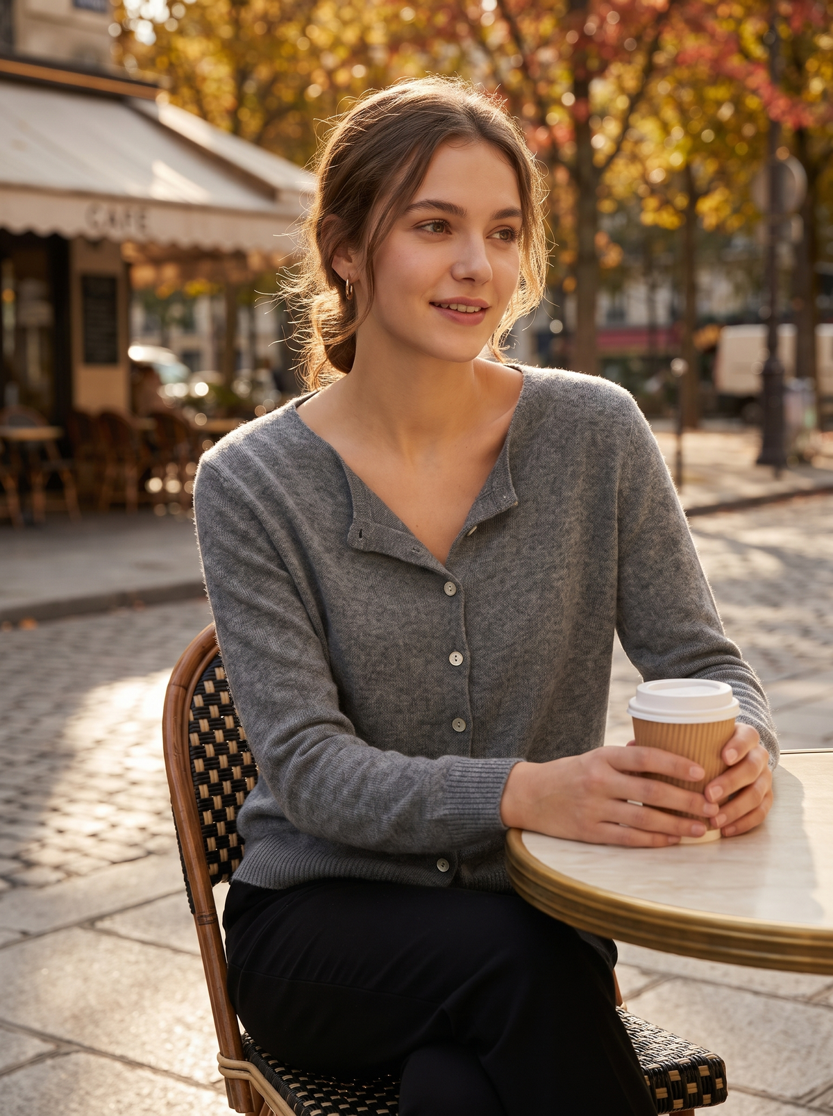 Henriette grey v neck cardigan worn by a model at an outdoor city cafe in autumn