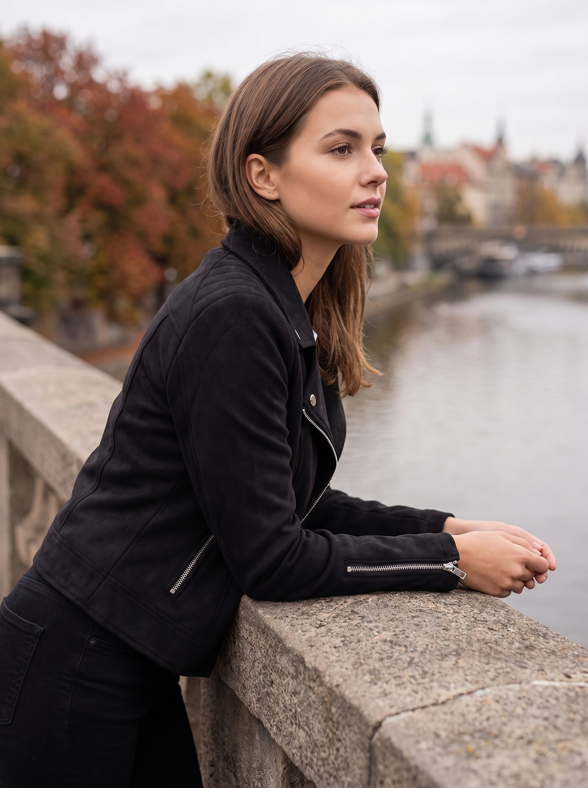 Romilly black suede moto jacket worn by a model on a city bridge in autumn