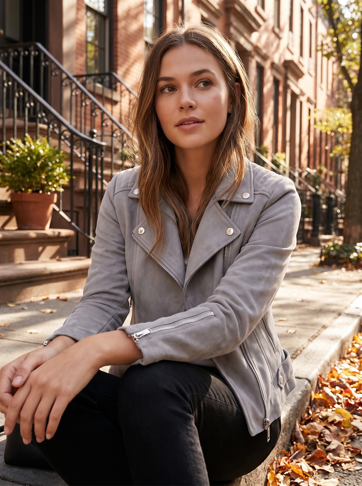 Romilly grey suede moto jacket worn by a model on city townhouse steps in autumn
