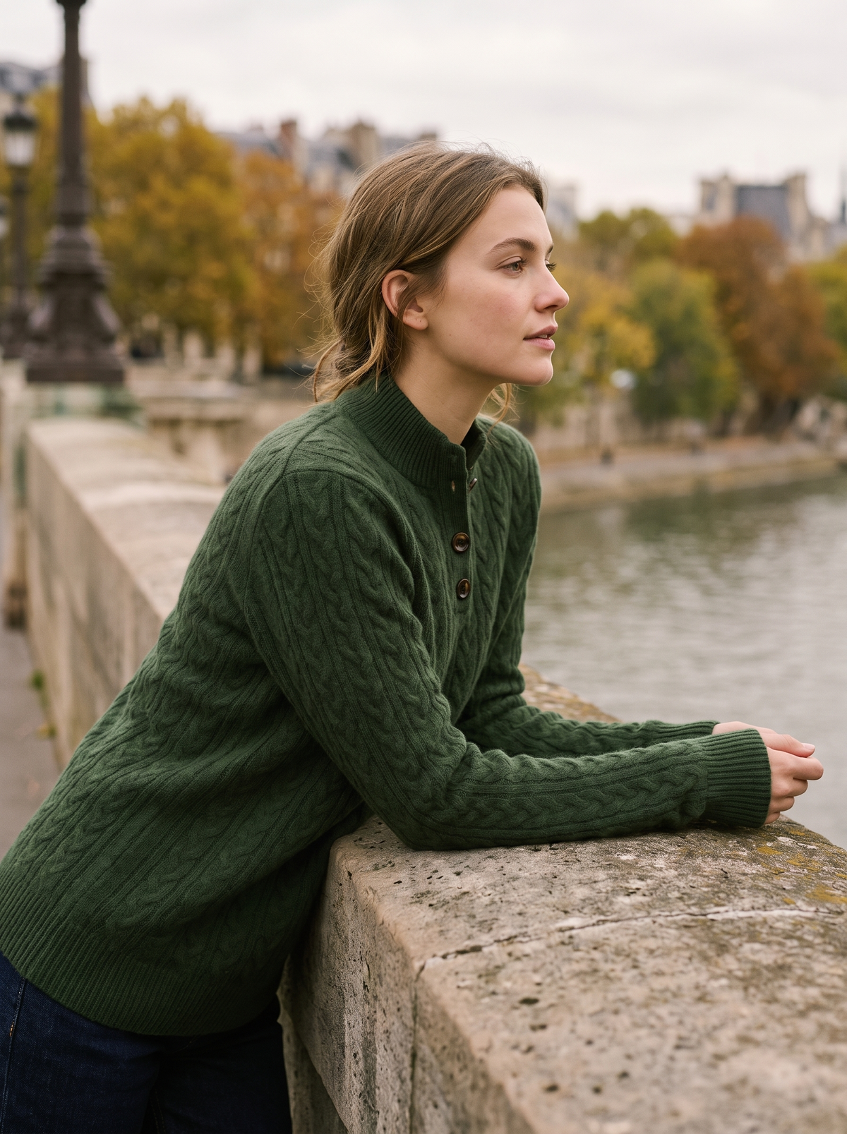Lavinia olive green cable knit sweater worn by a model on a city bridge in autumn