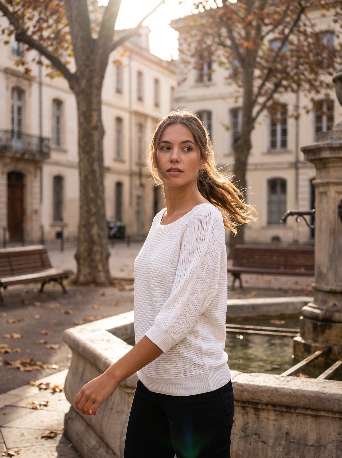 Giselle white three quarter sleeve knit sweater worn by a model by a fountain in a city square in autumn