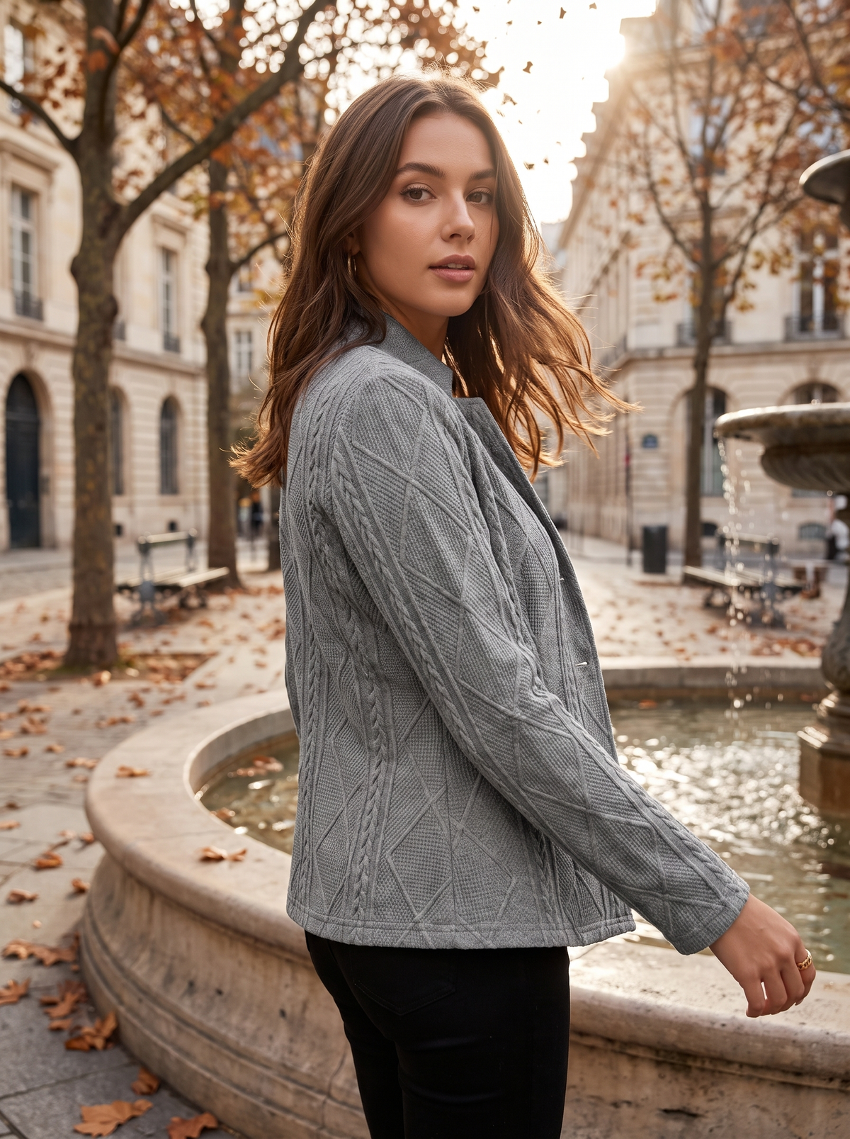 Octavia grey cable knit blazer worn by a model by a fountain in a city square in autumn