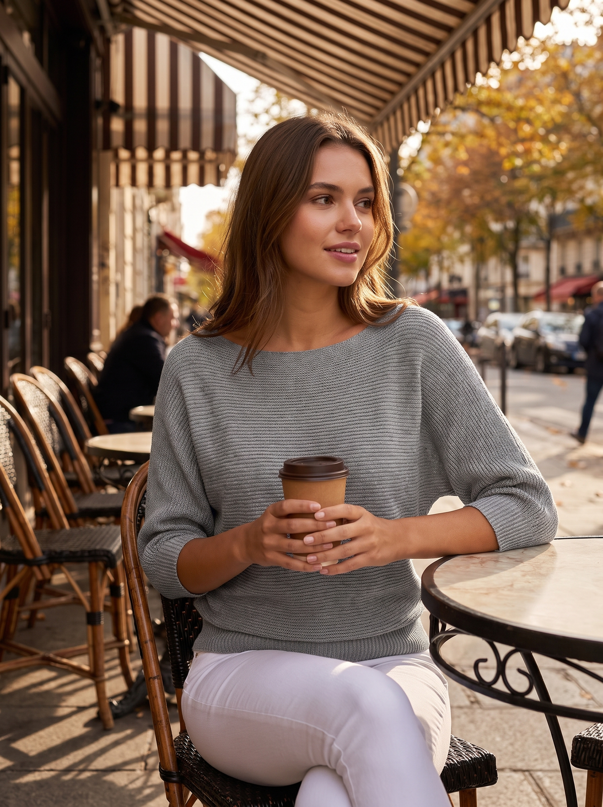 Giselle grey three quarter sleeve knit sweater worn by a model at an outdoor city cafe in autumn