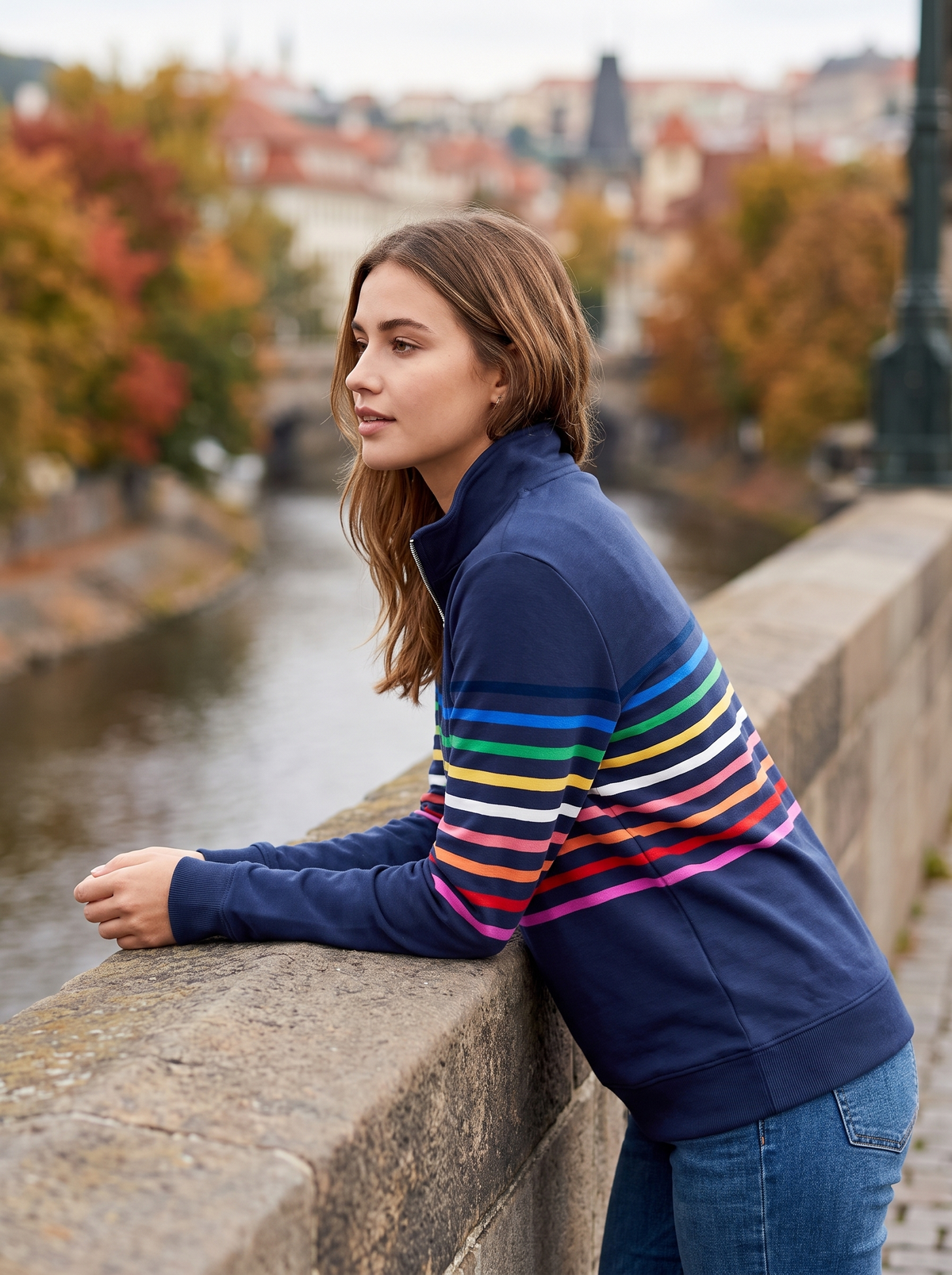 Zephyrine navy blue striped half zip sweatshirt worn by a model on a city bridge in autumn