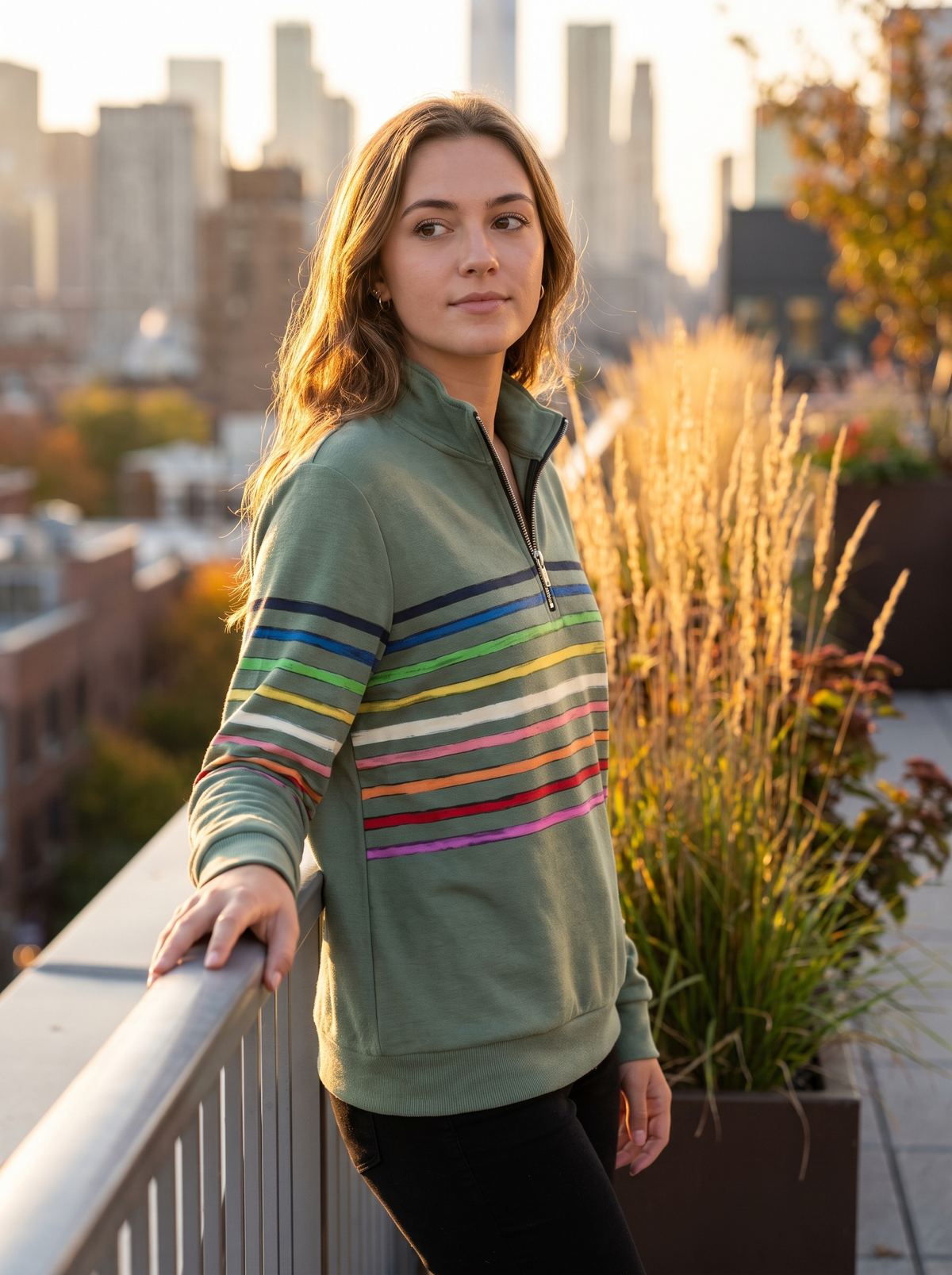 Thomasine green half zip sweatshirt worn by a model on a city rooftop terrace in autumn