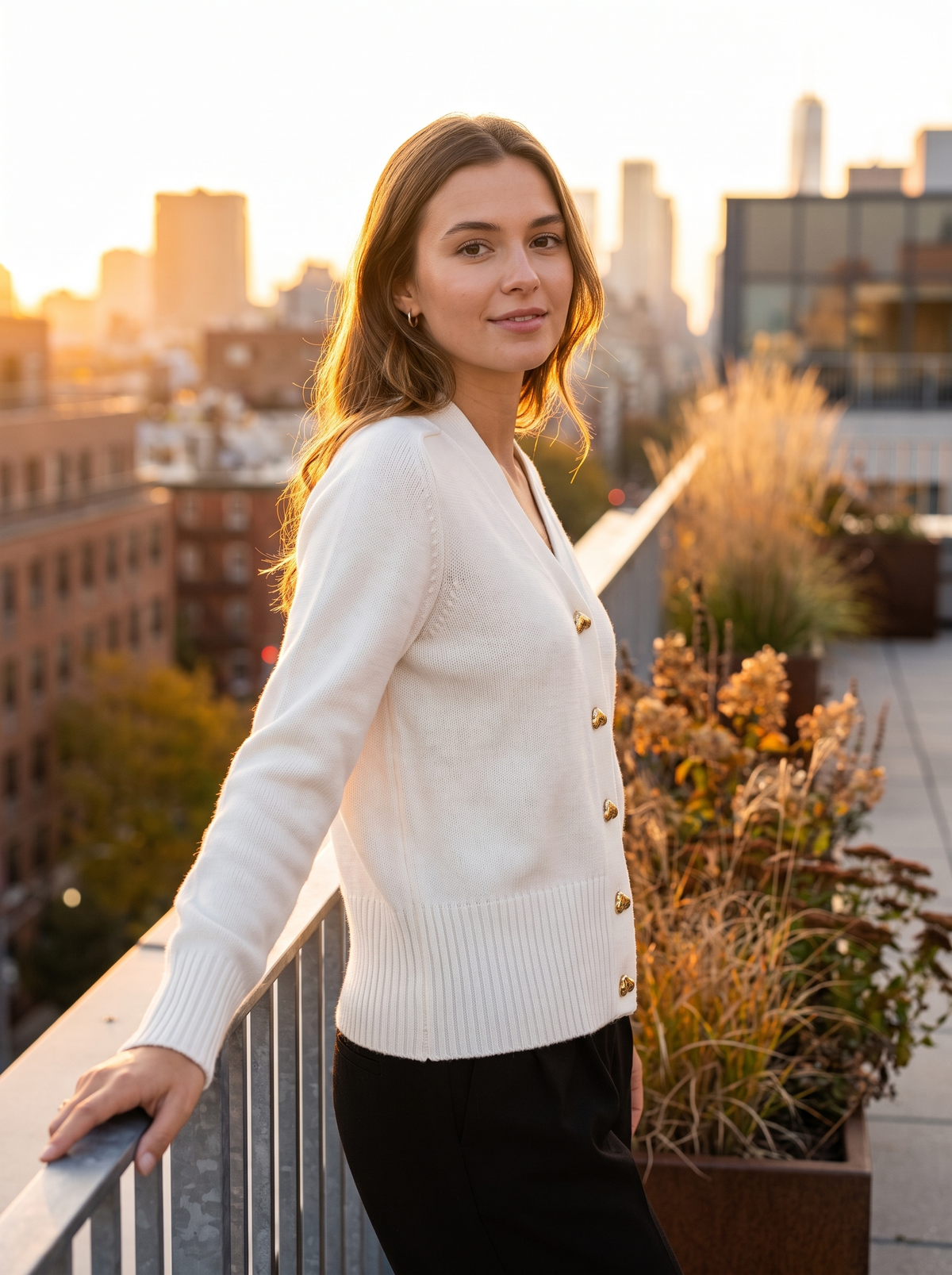 Yolande white ribbed knit cardigan worn by a model on a city rooftop terrace in autumn