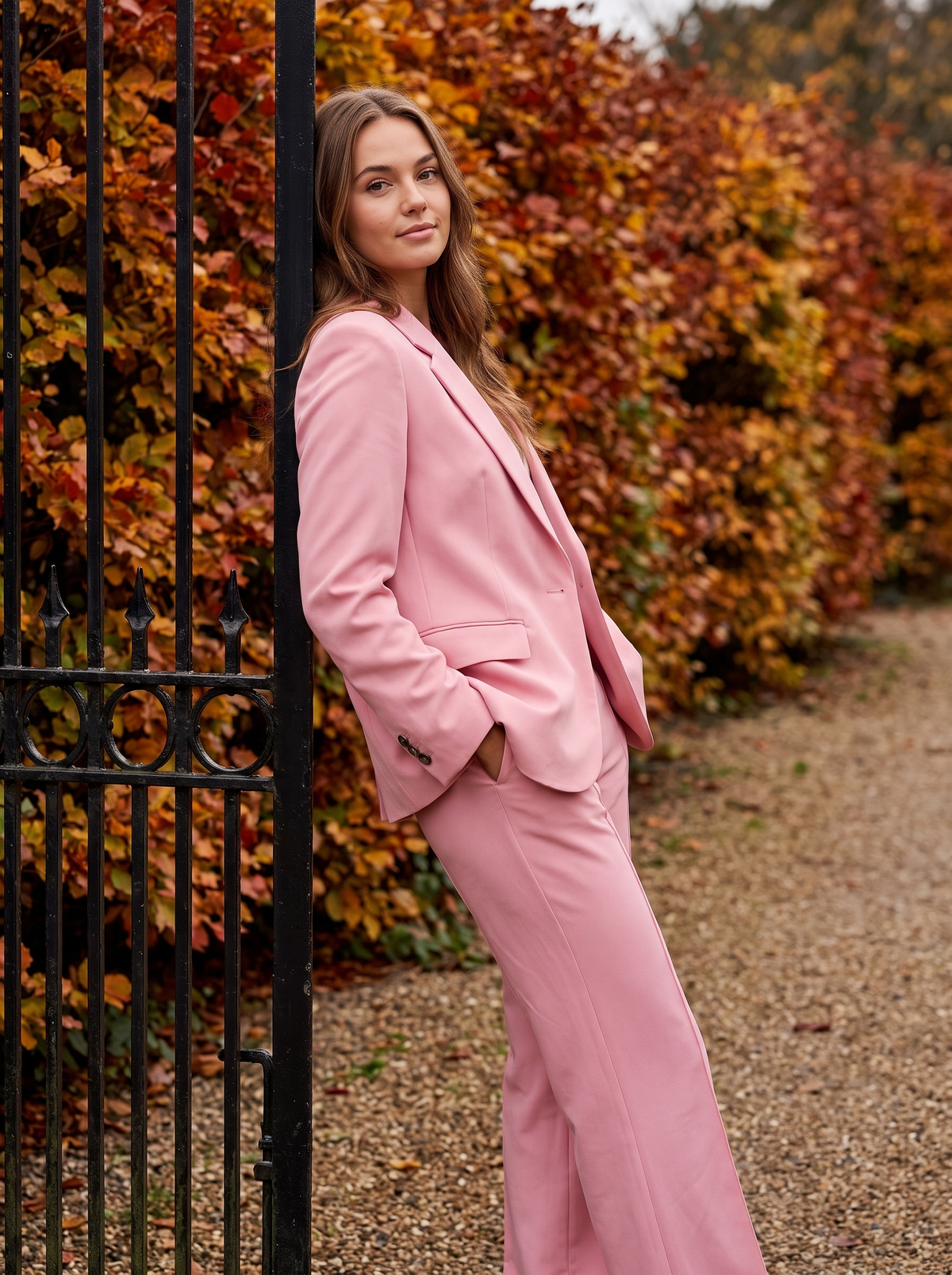 Pomeline pink wide leg blazer suit set worn by a model at a park gate in autumn