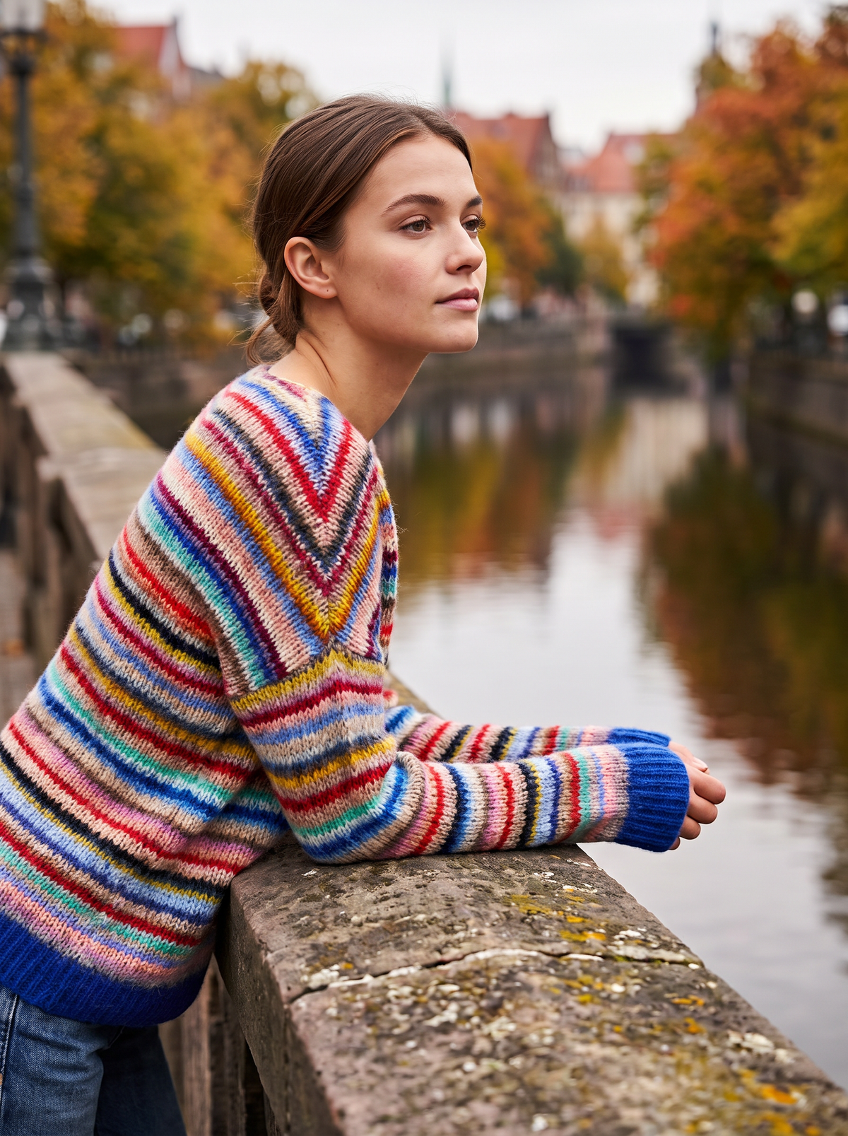 Vespera rainbow crew neck knit sweater worn by a model on a city bridge in autumn