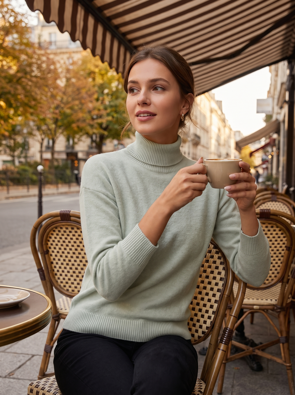 Clarisse light green roll neck ribbed sweater worn by a model at an outdoor city cafe in autumn