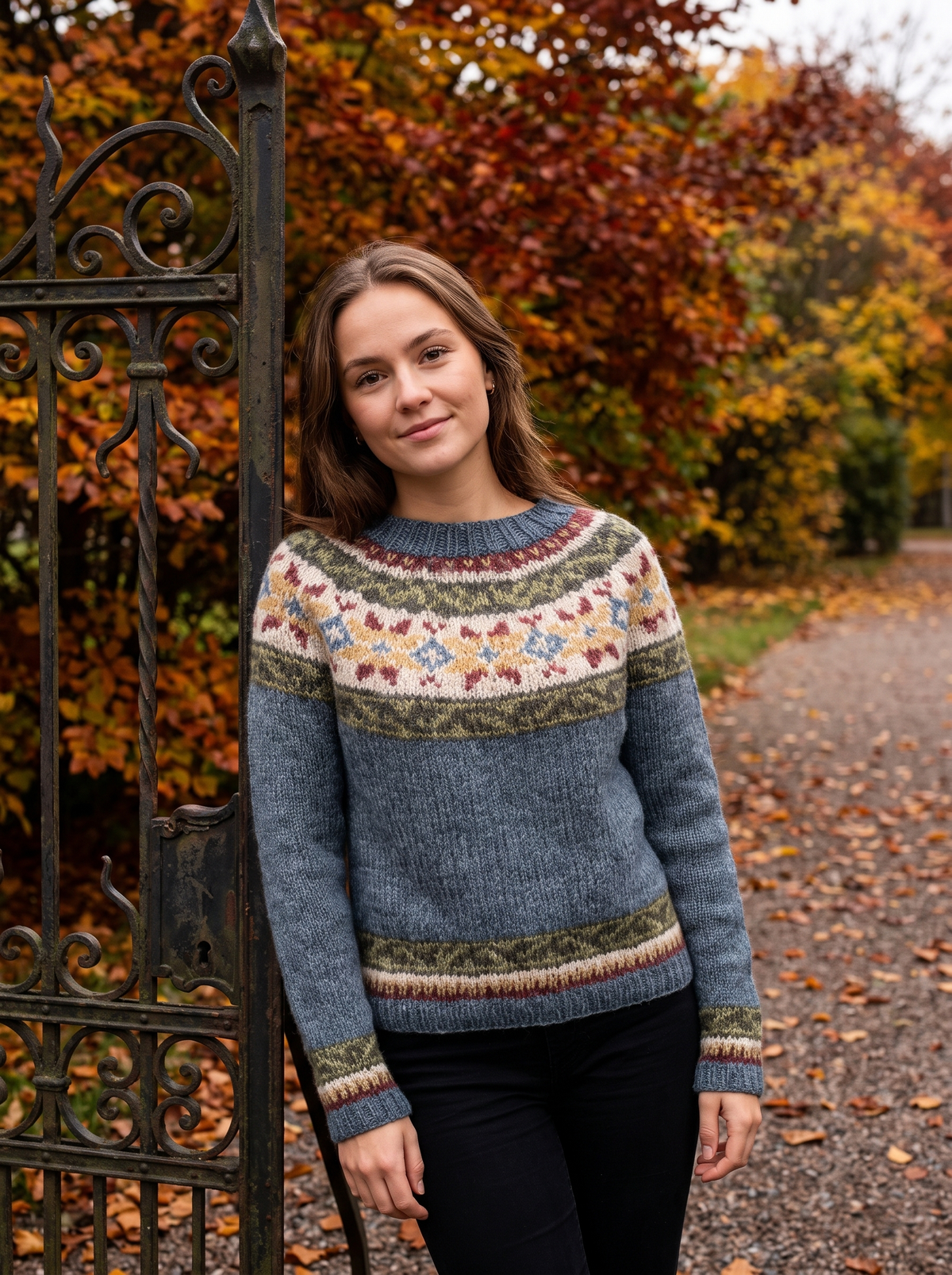 Vespera grey star crew neck knit sweater worn by a model at a park gate in autumn