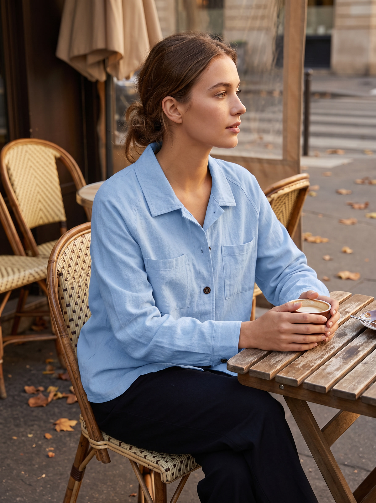 Linnea light blue cotton shirt jacket worn by a model at an outdoor city cafe in autumn