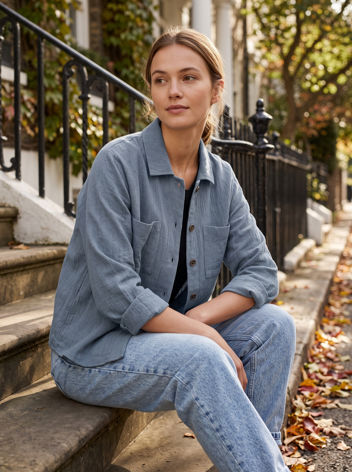 Linnea blue grey cotton shirt jacket worn by a model on city townhouse steps in autumn