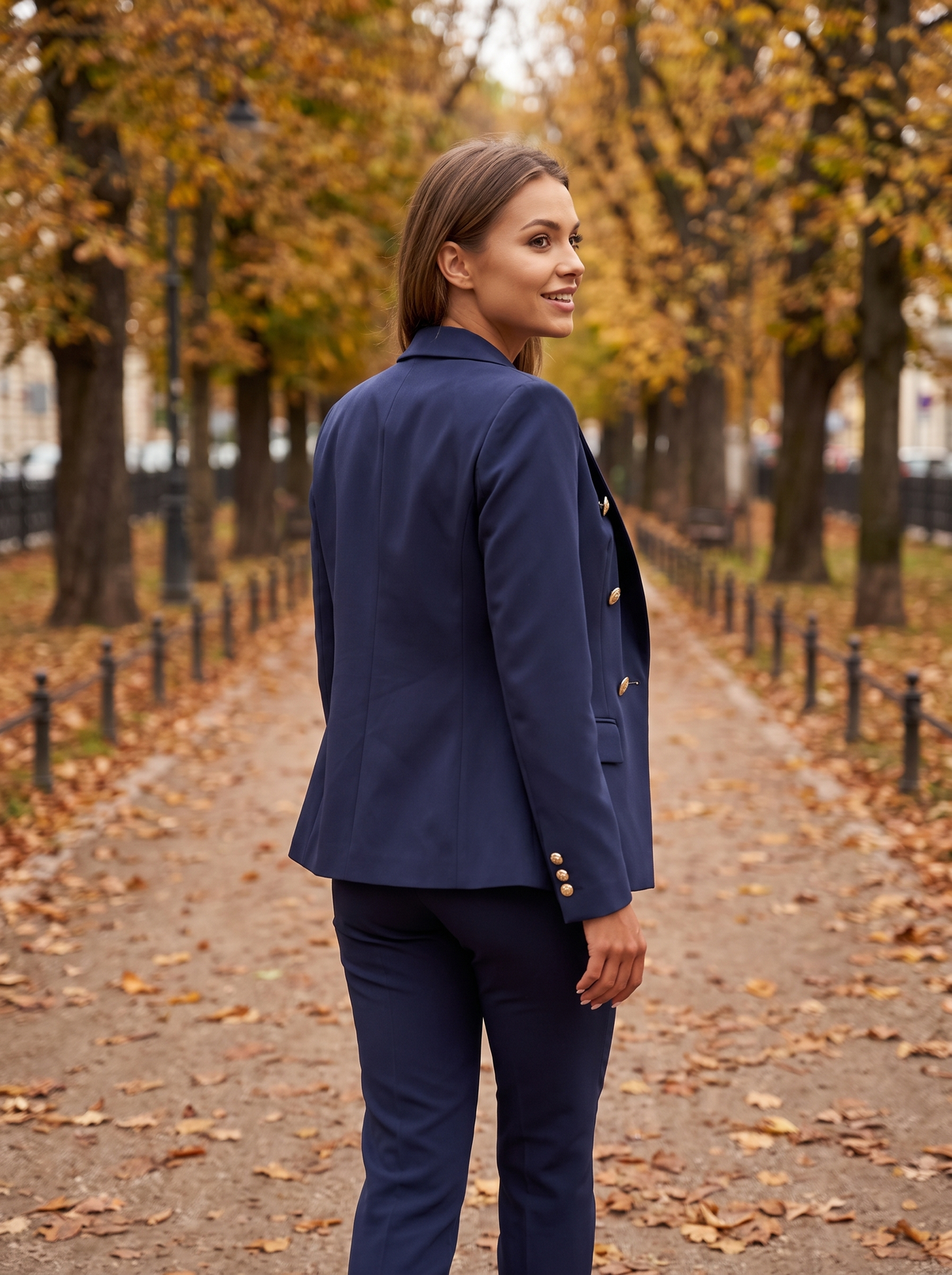 Xaviera navy blue double breasted blazer suit set worn by a model on an autumn park path in autumn