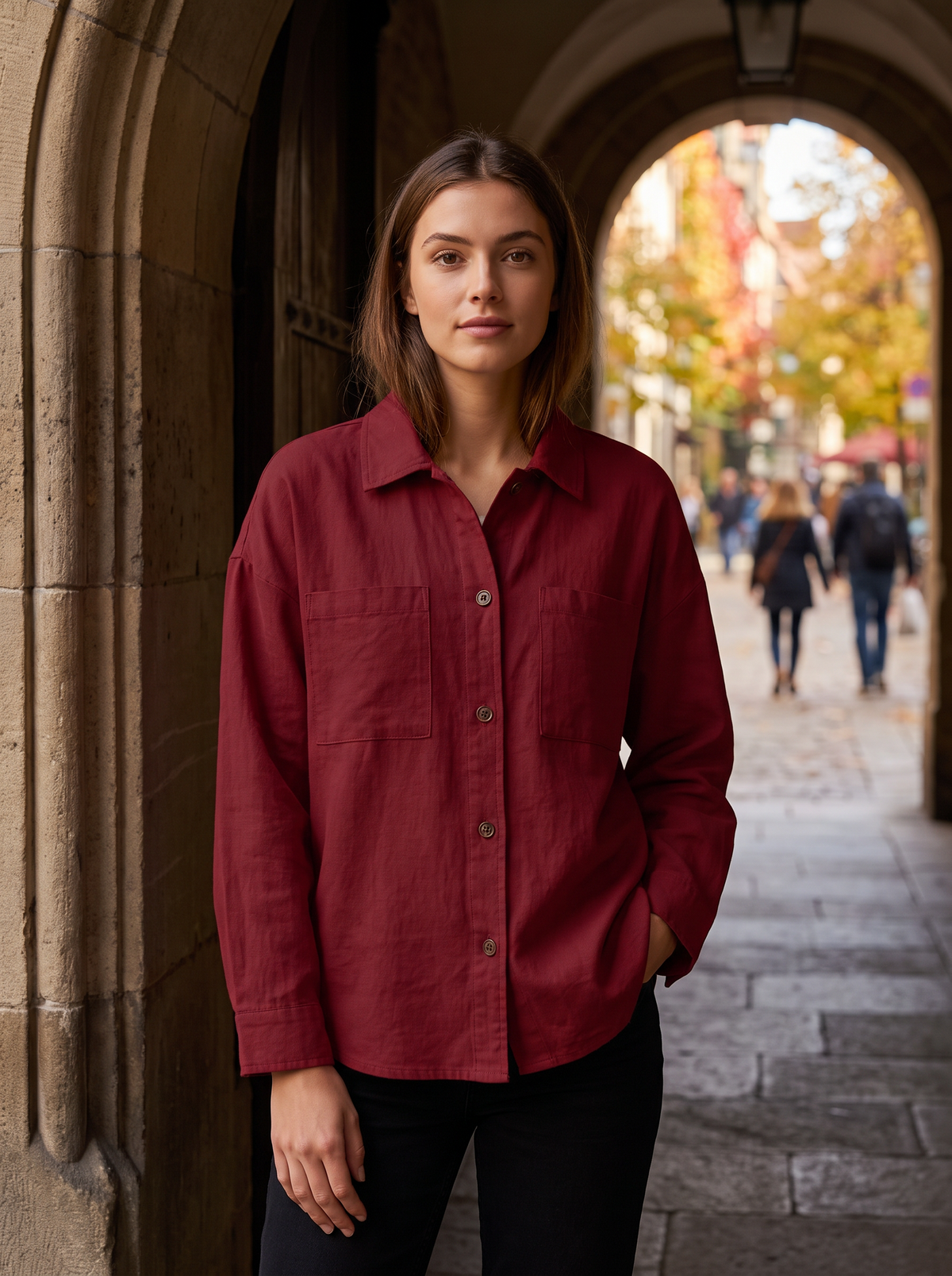 Linnea red cotton shirt jacket worn by a model in a stone archway in autumn