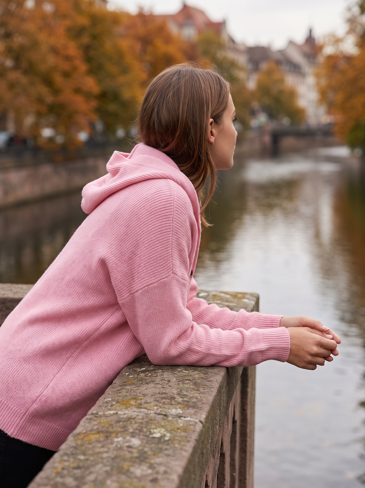 Bellamy pink hooded cardigan worn by a model on a city bridge in autumn