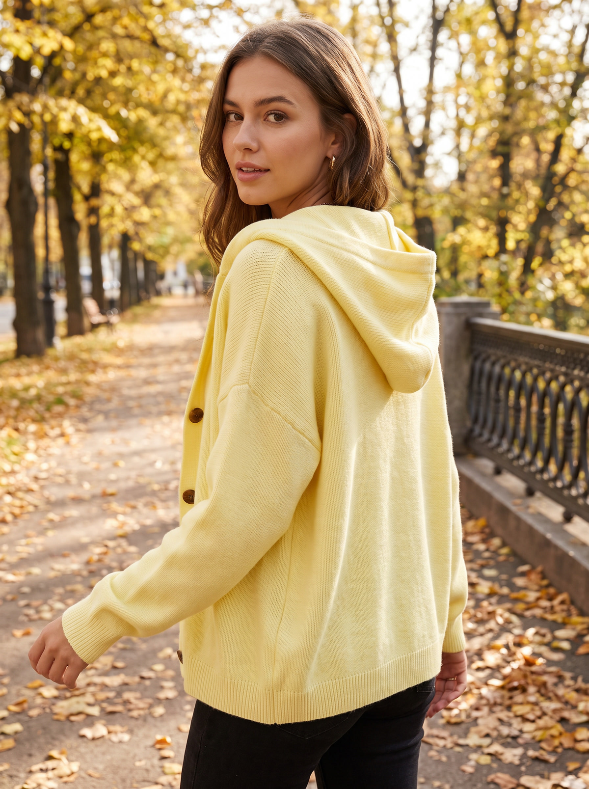 Bellamy yellow hooded cardigan worn by a model on an autumn park path in autumn