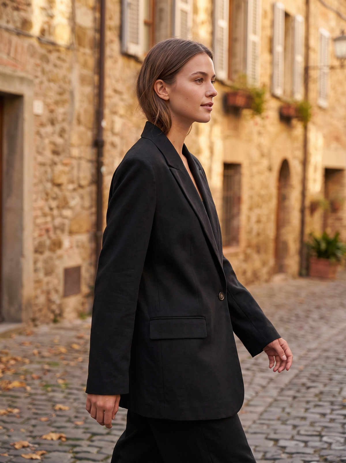 Eulalie black oversized blazer worn by a model in a cobbled city lane in autumn