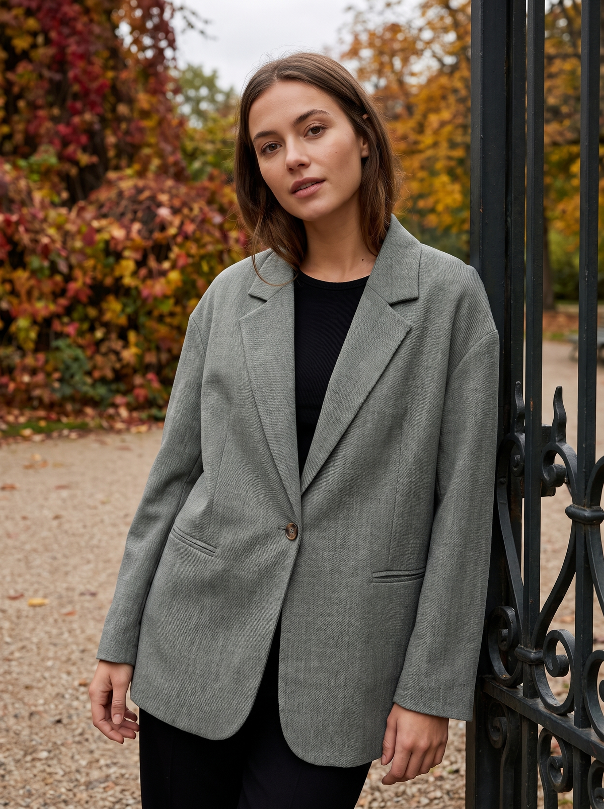 Eulalie grey oversized blazer worn by a model at a park gate in autumn