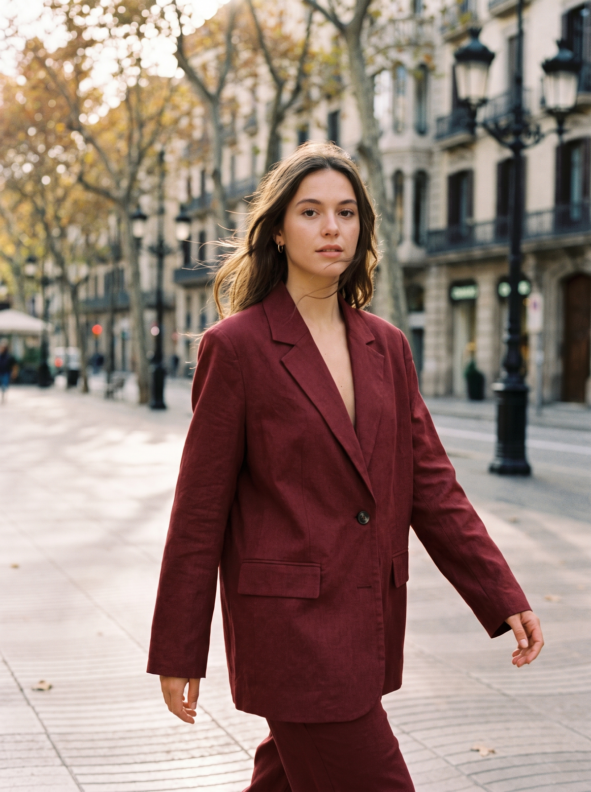 Eulalie burgundy oversized blazer worn by a model crossing a city boulevard in autumn