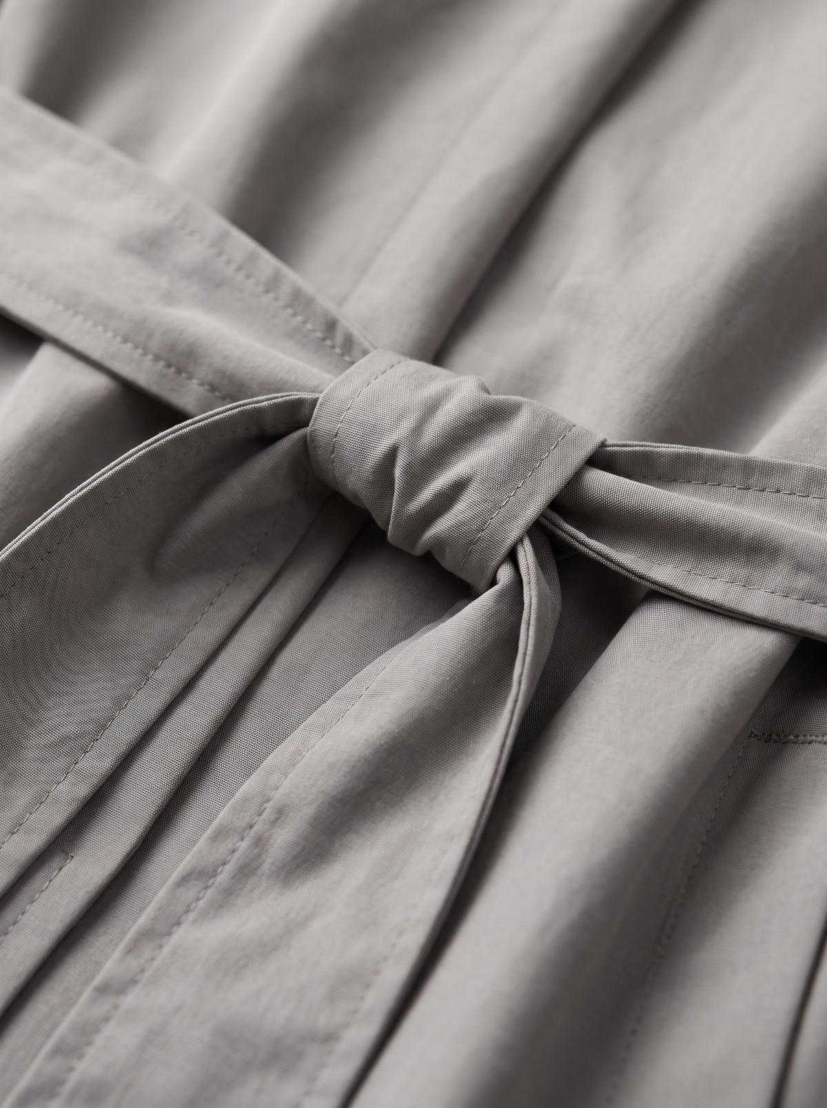 Detail of the Mirabelle oversized trench coat showing its material and finish