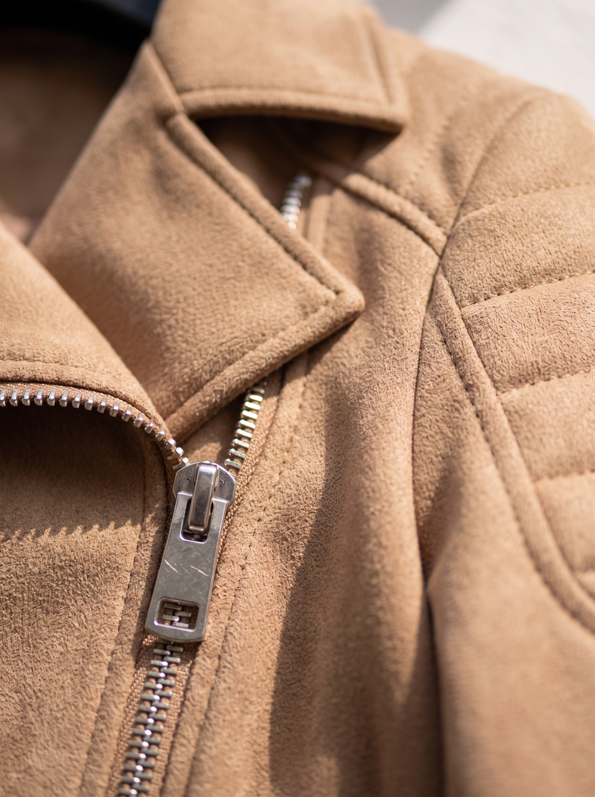 Detail of the Romilly suede moto jacket showing its material and finish